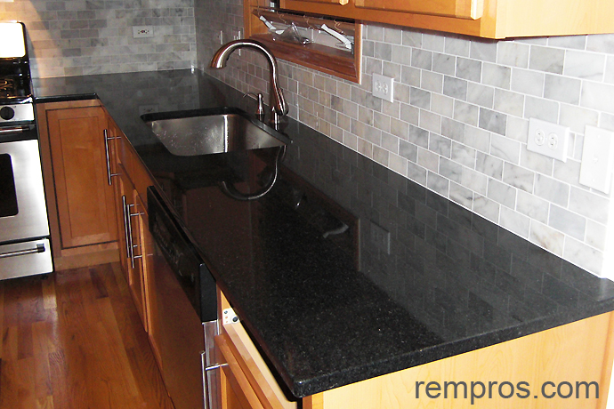granite-kitchen-countertop-in-combination-with-marble-tile-backsplash